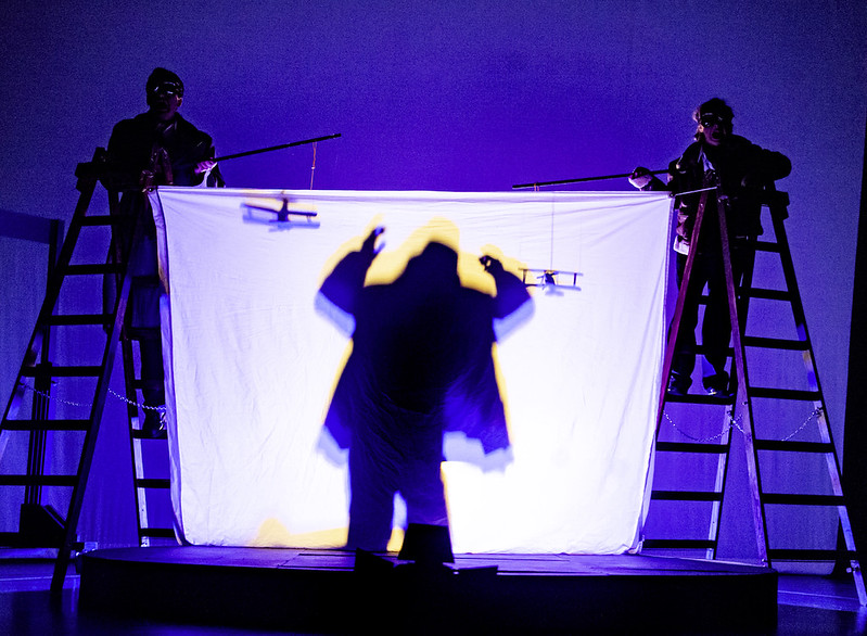 Shadow play: Hannay's silhouette on a sheet as two actors on ladders fly toy biplanes