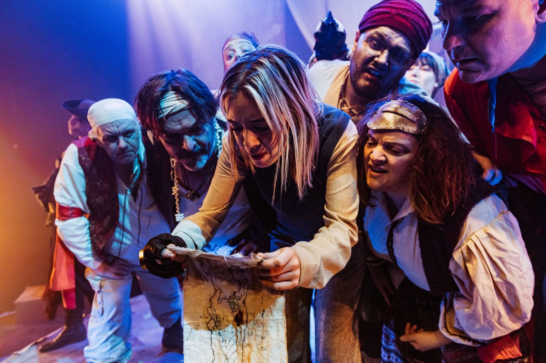 Jim Hawkins studies the treasure map, crowded by the pirate crew